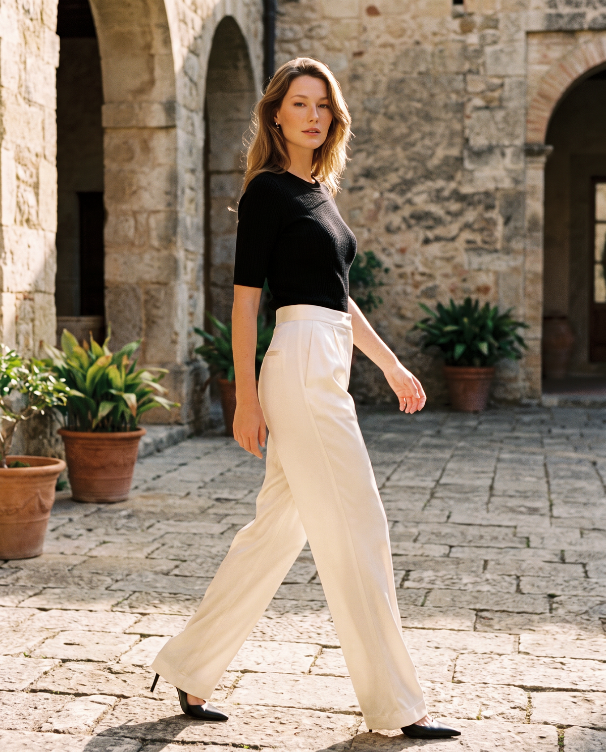 Pearl Ivory silk wide-leg trousers styled in a courtyard